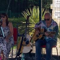 People outside playing guitar and singing