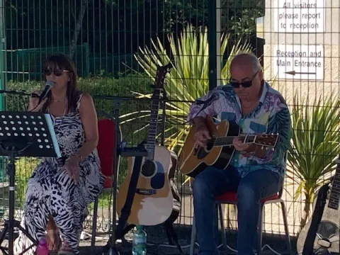 People outside playing guitar and singing